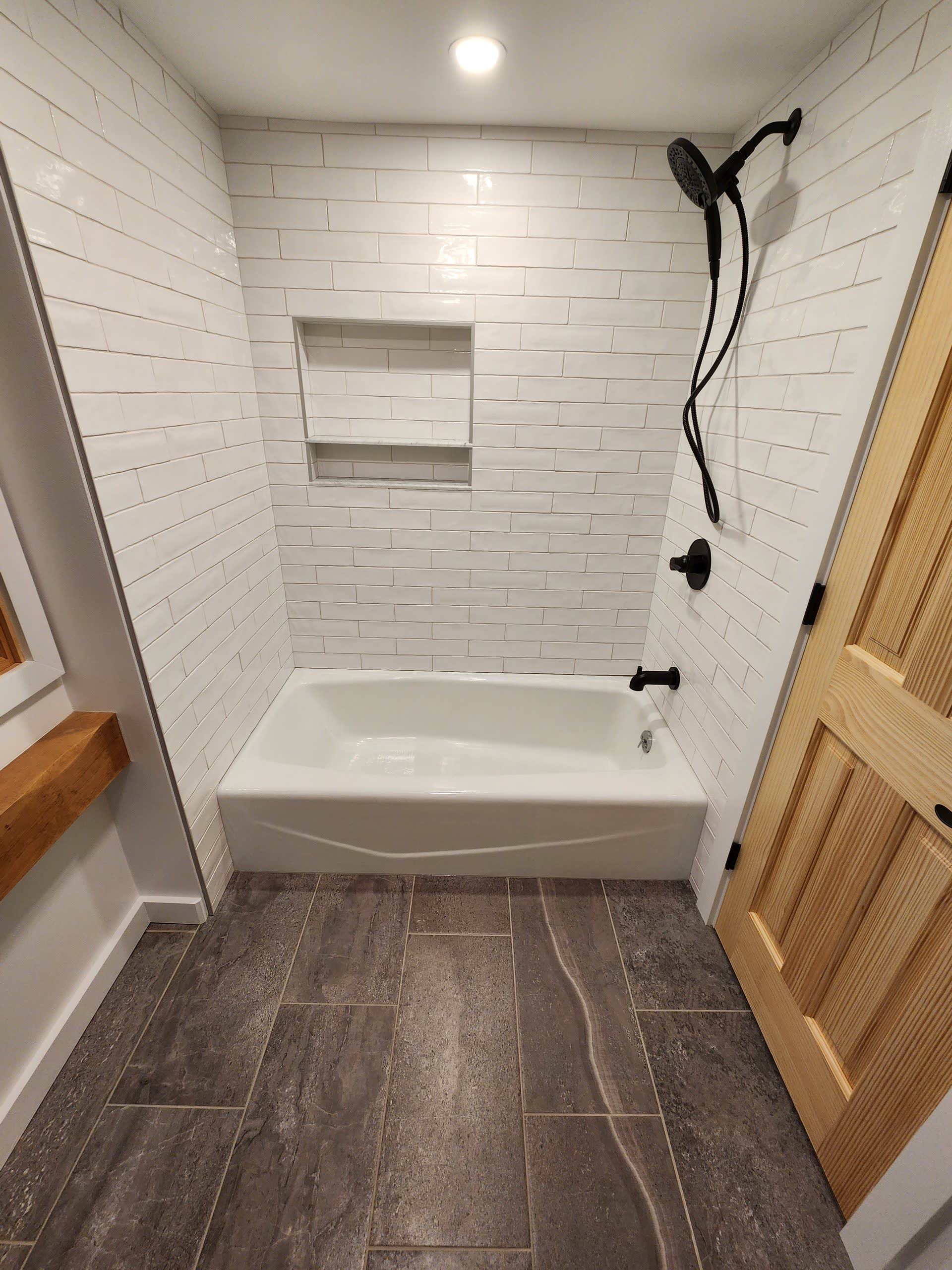 Tiled shower niche black fixtures winter construction bathroom remodel maine